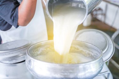 Dönüşüm için konteyner tankına süt döken işçiler.