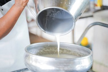 Dönüşüm için konteyner tankına süt döken işçiler.