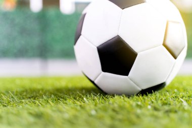 Yeşil çimen arka planında futbol topu.