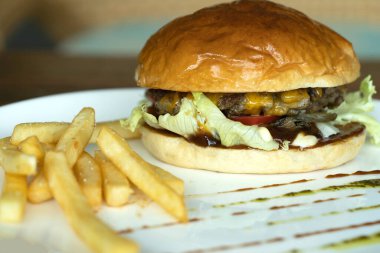 Biftek burger ve patates kızartması beyaz diskte iştah açıcı..