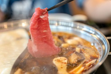 Baharatlı biftek shabu shabu sıcak kapta.