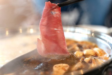 Baharatlı biftek shabu shabu sıcak kapta.