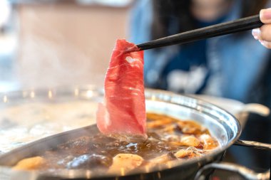 Baharatlı biftek shabu shabu sıcak kapta.