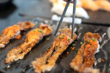 Yemek çubuklarıyla suşi yemek. Restoranda taze suşi Japon yemeği var..