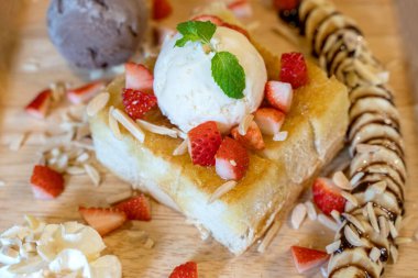 Ahşap tabakta dondurmalı çilekli tost..