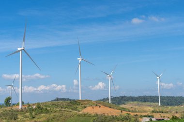 Rüzgar türbinleri mavi gökyüzü ile elektrik üretiyor, yenilenebilir enerji kaynağı.