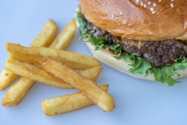 Beyaz masada taze ev yapımı hamburger ve patates kızartması..