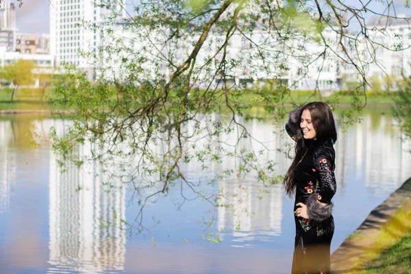 Geleneksel Çin elbiseli Avrupalı genç kız nehir kıyısındaki bahar parkında Cheongsam