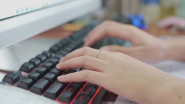 Ağır çekimin yakın çekimi. Bir kadın elleri dizüstü bilgisayarda klavyeyle evden çalışmakla meşgul.