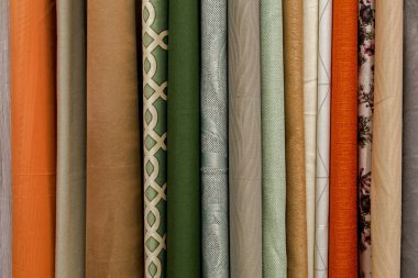 Kenarlardaki yuvarlak uçların bir kısmı dikey olarak yeşil, gri, bej, turuncu ve kahverengi tonlarda kumaş perdelerde asılı duruyor. Tasarım için doğal tekstil arkaplanı.