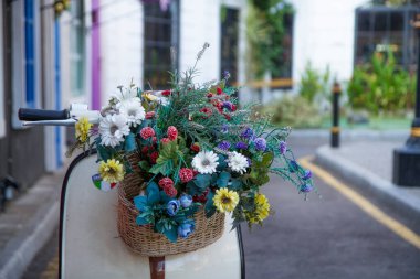Scooter 'ın önünde asılı bir buket çiçek.