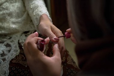 Gelin, tırnak cilası kullanıyor.