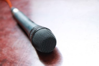 Masadaki siyah mikrofon bulanık arka planda. kopyalama alanı ile