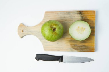 Kesme tahtasında guava tohumu ve beyaz arkaplanda izole edilmiş bıçak yok