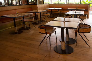 Restoranda boş sandalye ve masa var.