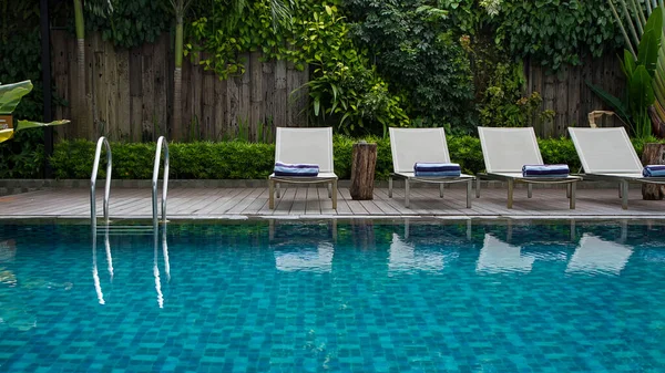 Deck chair and swimming pool with green vertical garden