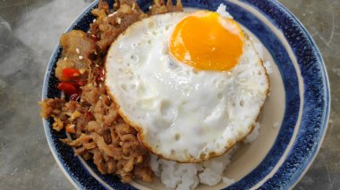 Bir kase kızarmış yumurta, domuz pastırması ve pilav.