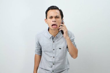 Üzgün ağlayan Asyalı Endonezyalı izole edilmiş bir geçmişle telefon görüşmesi yapıyor.