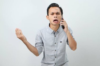 Üzgün ağlayan Asyalı Endonezyalı izole edilmiş bir geçmişle telefon görüşmesi yapıyor.