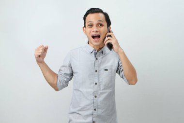 Mutlu Asyalı Endonezyalı baş parmak hareketi ile telefon görüşmesi yapıyor. izole arkaplan 