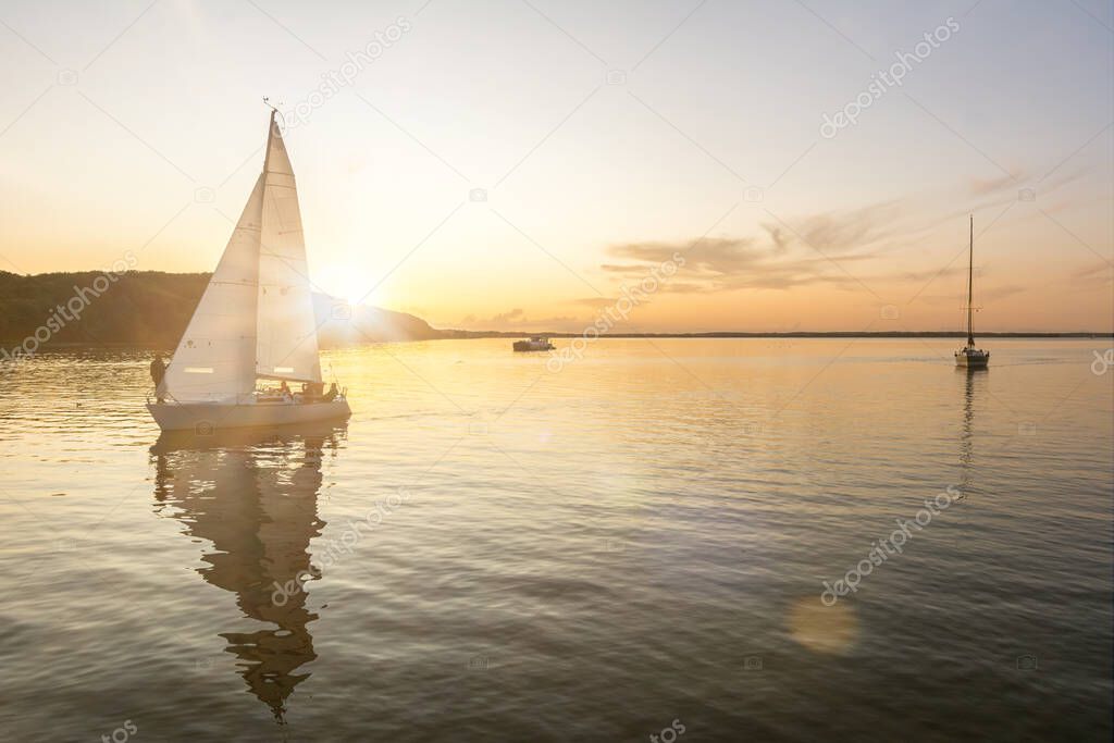 Sailing boats coming back into the harbor during beautiful sunset at the Baltic Sea