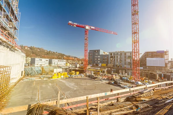 Large building site with foundations and cranes and scenic lens flare