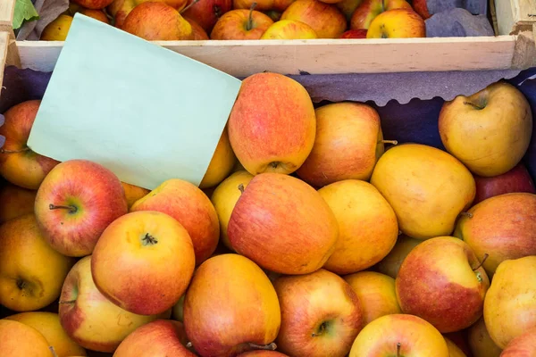 Fresh organic apples at the farmers market with blank cardboard sign