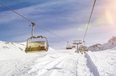 Kış mevsiminde bir kayak merkezinde, manzaralı mercek parlamasıyla.