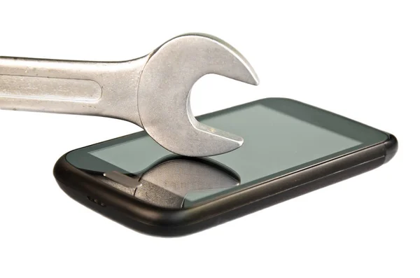 Beyaz arkaplan önünde akıllı telefon ve İngiliz anahtarı