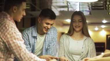 Arkadaşlar bilardo masasının yanında taş kağıt makas oynarlar.