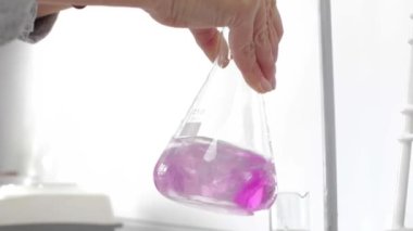 El, kimyasal analiz sırasında matarayı döndürür..