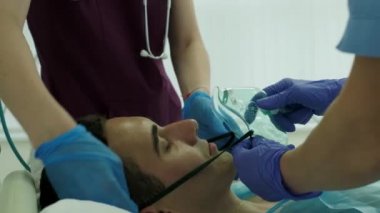 Hemşireler yoğun bakımdaki hastalarına oksijen maskesi takarlar.