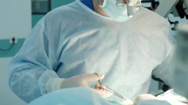 Cerrah ameliyat sırasında kesiği hastaya diker.