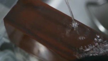 El, taş ve su kullanarak bıçağını keskinleştirir.