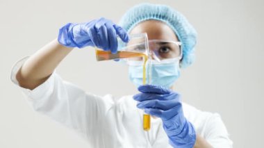 Kimyasal laboratuvar sahnesi: cam tüpte motor yağı veya bal gözlemleyen çekici genç doktora öğrencisi.
