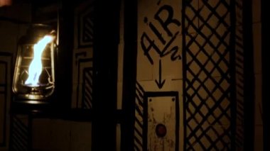 hand with a kerosene lamp presses the air supply button. Oil lamp