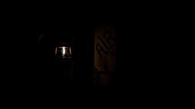 hand with a kerosene lamp presses the air supply button. Oil lamp