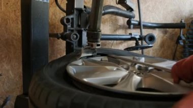 Change a tyre, Car mechanic is changing a tyre in a garage