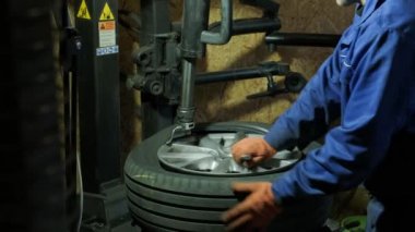 Change a tyre, Car mechanic is changing a tyre in a garage