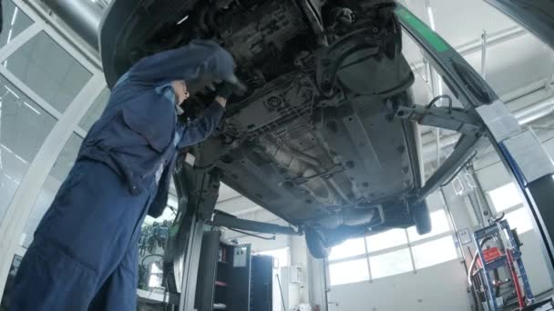 Mecânico Automóveis Trabalhando Embaixo Máquina Elevação Carro Garagem Loja Reparação — Vídeo de Stock