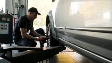 Tamir istasyonunda kaldırılan otomobilin vidaları vidalanmış veya sökülmüş araba tamircisi