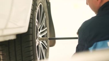 Tamir istasyonunda kaldırılan otomobilin vidaları vidalanmış veya sökülmüş araba tamircisi