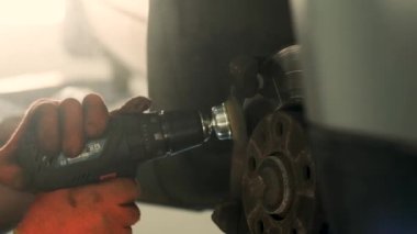 Tamirci varil frenindeki tozu temizlemek için bir fırça kullanıyor. Seçici odak.