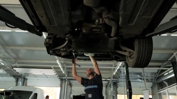 Mecânico Automóveis Trabalhando Embaixo Máquina Elevação Carro Garagem Loja Reparação — Vídeo de Stock