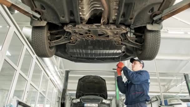 Mecânico Automóveis Trabalhando Embaixo Máquina Elevação Carro Garagem Loja Reparação — Vídeo de Stock