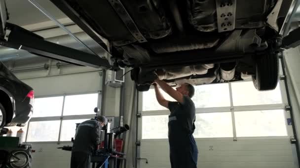 Otomobil Tamircisi Garajda Araba Kaldırma Makinesinin Altında Çalışıyor Otomobil Tamirhanesi — Stok video