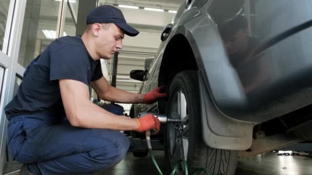 Car Mechanic Screwing Unscrewing Car Wheel Lifted Automobile Repair Service — Stock Video