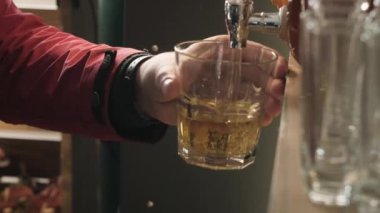 Adam partide bardağa taze meyve suyu döküyor.