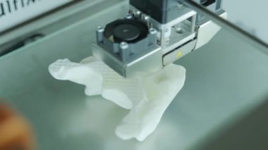 Modern 3D yazıcı figürü makro-yakın yazıcı. Üç boyutlu 3D yazıcı, laboratuarda plastik beyaz renk modellemesi yapıyor. Beyaz arkaplan ile 3d yazdırma işlemi
