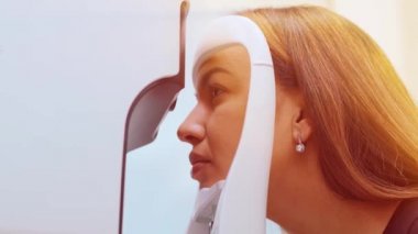 Göz kliniğindeki güzel kadın hasta vizyonunu test eden göz doktoru.